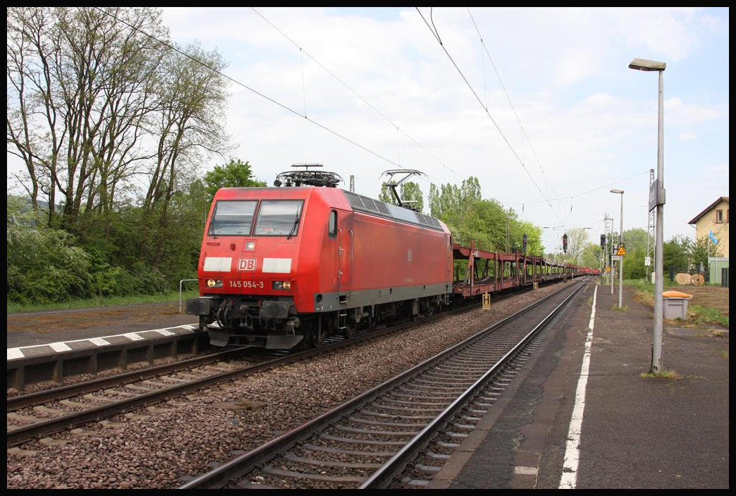 DB 145054 kommt mit einem Autotransportzug am 29.4.2018 um 14.08 Uhr in Richtung Trier fahrend durch den Bahnhof Hetzerath.