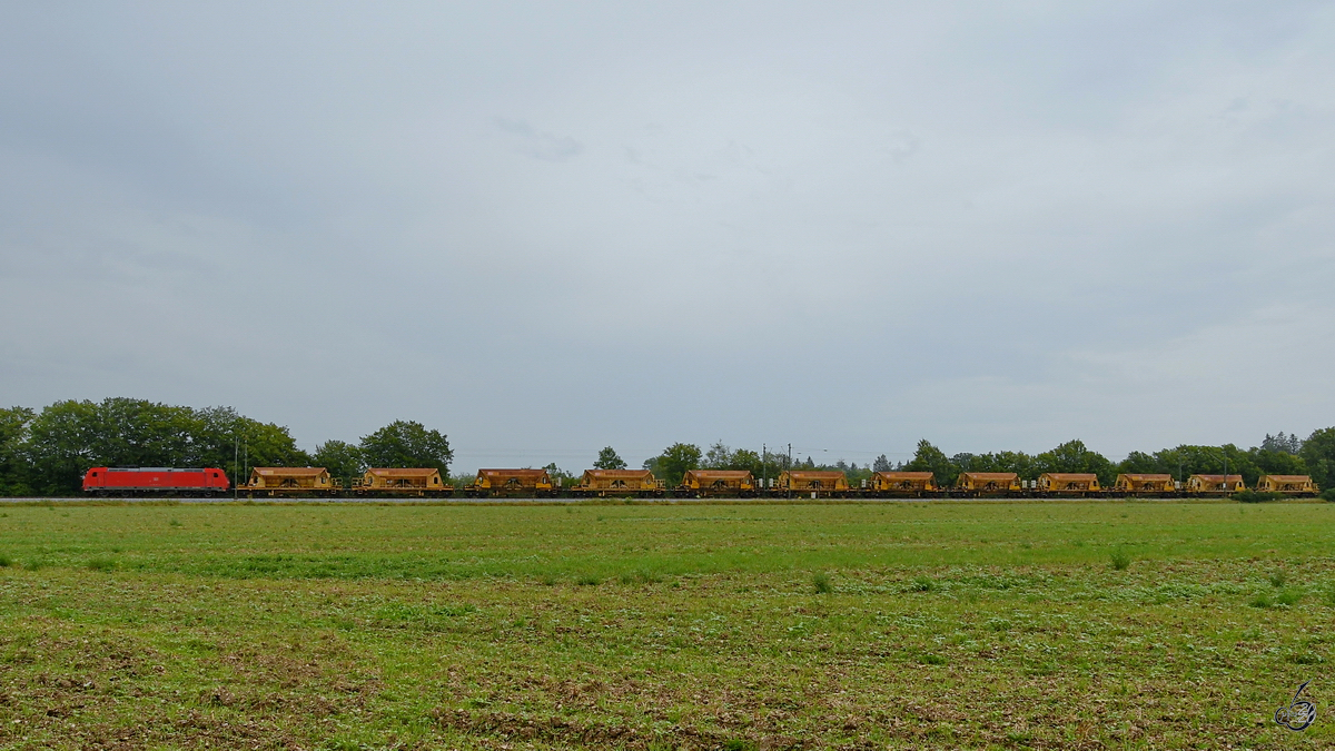 DB 185 228-4 zieht einige Selbstentlade-Schotterwagen, so gesehen im August 2020 in Oberschleißheim.