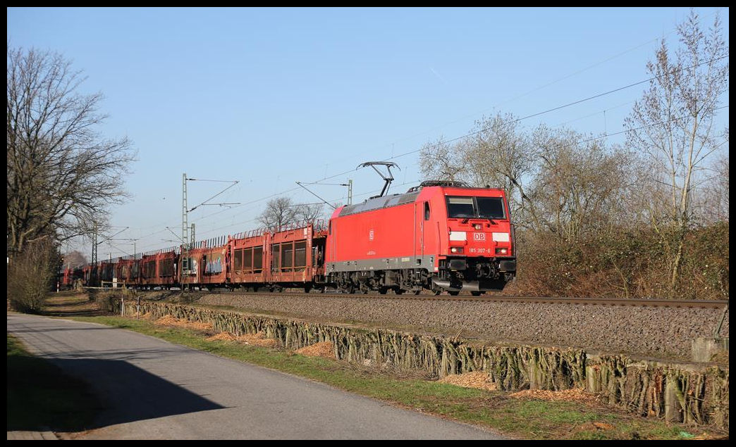 DB 185307-6 ist hier in Hasbergen am 27.2.2019 um 10.00 Uhr mit einem Auto Leer Transportzug unterwegs nach Osnabrück.