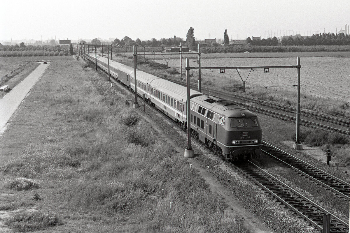 DB 218 137-8 unterwegs auf der Strecke Arnhem - Nijmegen mit dem D-216  Austria Expres (Klagenfurt Hbf - Amsterdam CS). Links im Hintergrund sieht man das ehemalige Bahnhofsgebäude Ressen-Bemmel. Die DB-Lok führte den Zug über Kleve und Nijmegen bis Arnhem. Einen guten Standpunkt bot der Damm, auf welcher die Autobahn A15 später erbaut wurde. Ressen Aansluiting, 17.06.1978. Scanbild 91504, Kodak Tri-Xpan.