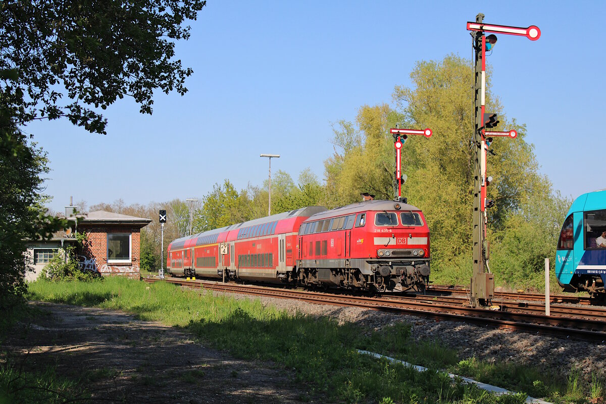DB 218 435-6 zieht ihre RB85 von Neustadt(Holst) nach Lübeck Hbf durch Neustadt(Holst)Gbf, während der Gegenzug bereits zwecks Zugkreuzung im Nachbargleis wartet. (12.05.2023)