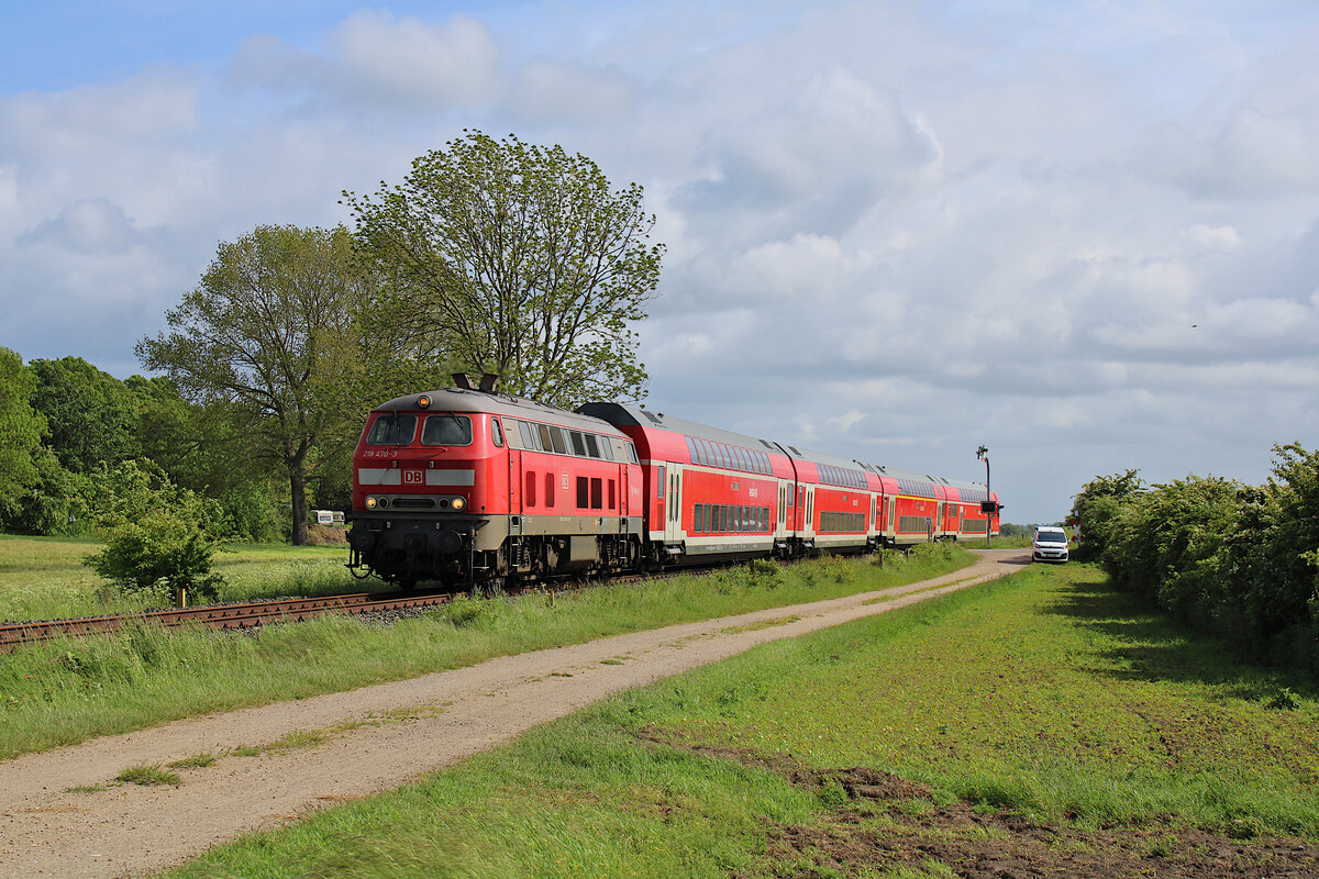DB 218 470-3 zieht am 28.05.2022 den Strand-Express von Hamburg kommend über die Vogelfluglinie nach Puttgarden auf der Insel Fehmarn und dieselt hier kurz vor der Fehmarnsundbrücke bei Großenbrode gen Norden.