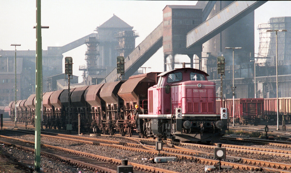 DB 290 195-7 rangiert vor bekannter Kulisse des EBV in Alsdorf am 09.11.1983. Erster Wagen hinter der Lok war ein Tds; für den Kohleverkehr eher unüblich. Diese Bauart habe ich dort  mehrfach wahrgenommen. Scanbild 93288, Kodacolor400.
