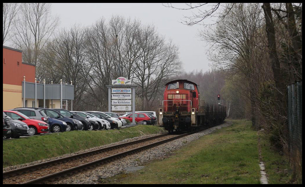 DB 295059-0 ist hier am 2.3.2019 um 11.30 Uhr mit einem langen Güterzug in Hasbergen auf dem Weg zum Stahlwerk in Georgsmarienhütte. Der Zug befährt die eingleisige Werkbahn.