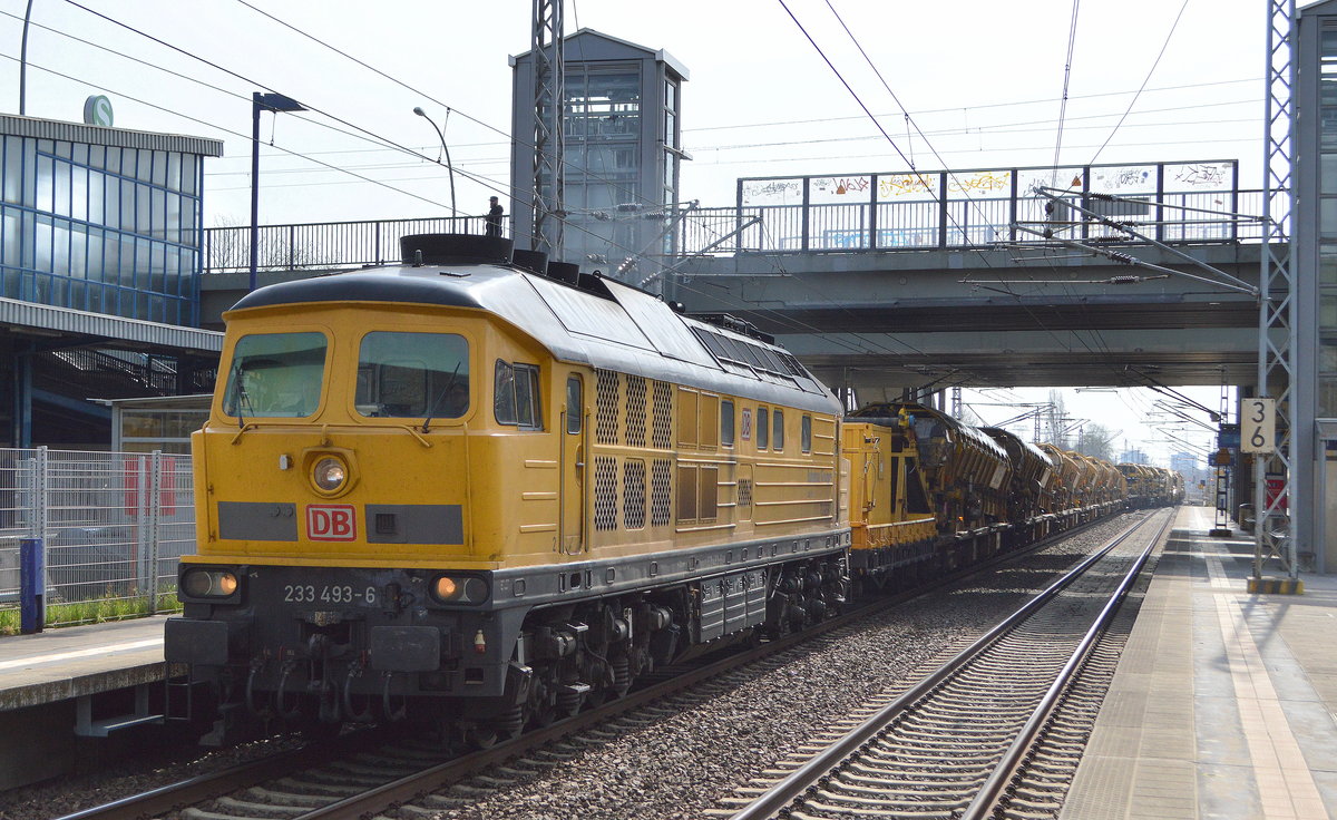 DB Bahnbau Gruppe mit  233 493-6/Lok 13  (NVR-Nummer  92 80 1233 493-6 D-DB ) fährt mit dem Gleisumbauzug SUM 315  Büffel  und mehreren Materialförder- und Silowagen vom Gelände Industrieübergabe Berlin Nordost am 09.04.21 Durchfahrt Bf. Berlin Hohenschönhausen.
