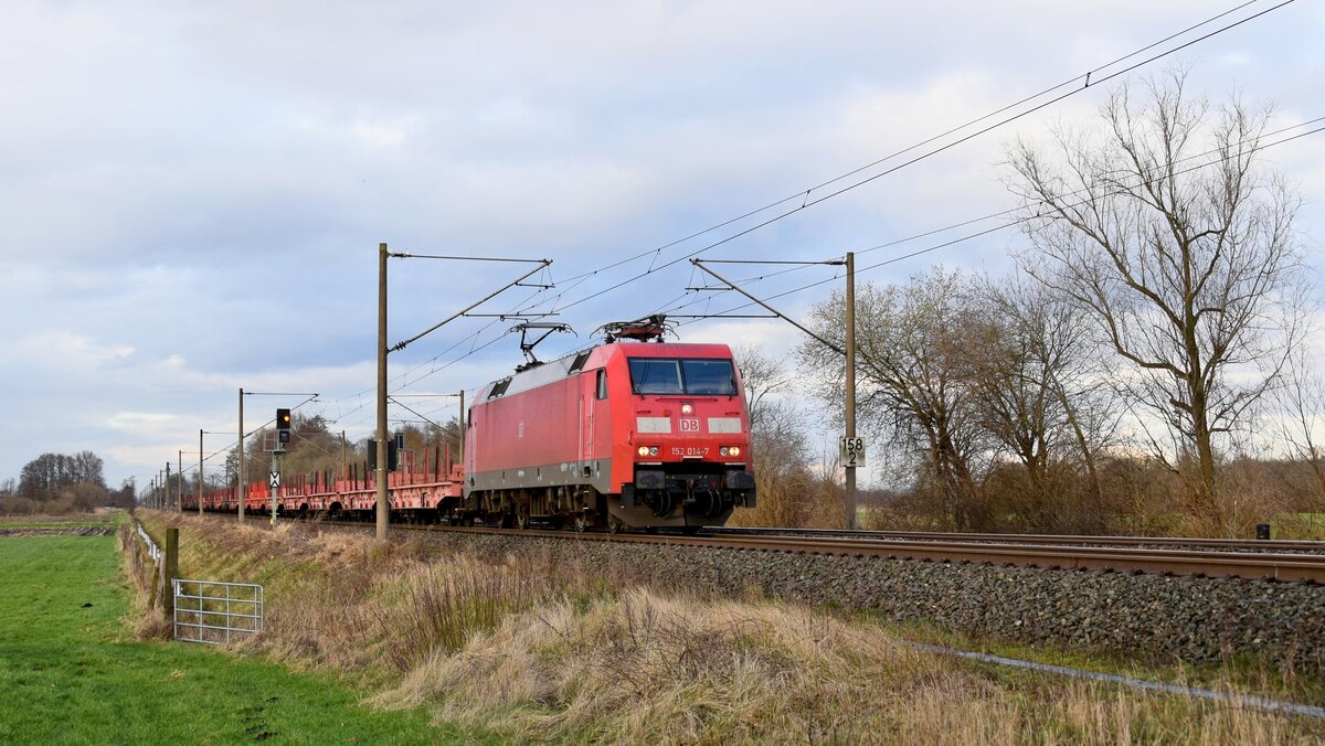 DB Cargo 152 014-7 mit Rungenwagen in Richtung Osnabrück (Hüde, 23.02.2024).
