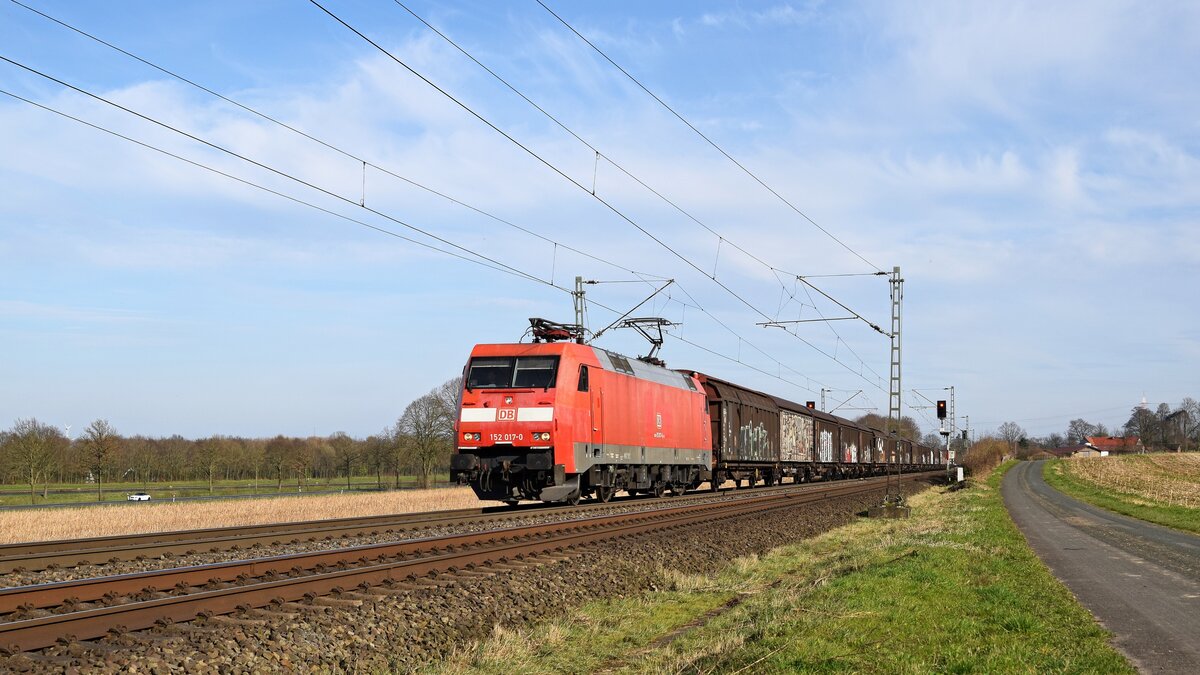 DB Cargo 152 017-0 mit Schiebwandwagenzug in Richtung Osnabrück (Bohmte-Stirpe, 14.03.2024).