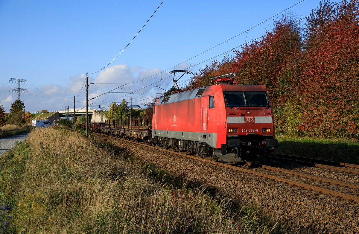 DB Cargo 152 038 mit Langschienen und Schwellen für die Baustelle bei Bernau(?) am 18.10.2022 durch Teschenhagen bei Stralsund.
