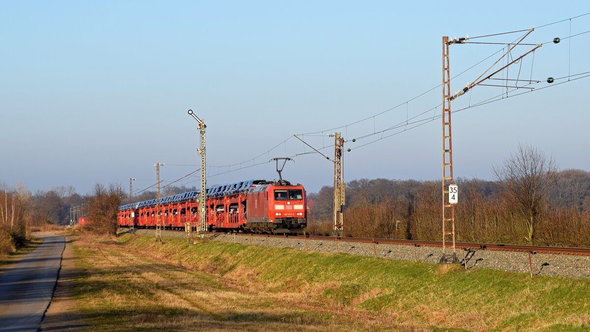 DB Cargo 185 012 mit Autotransportzug in Richtung Minden (Windheim, 28.02.2022). Aufgrund von Bauarbeiten auf der KBS 385 zwischen Syke und Kirchweyhe wurden etliche Züge über die  NATO-Bahn   (Minden - Nienburg) umgeleitet.