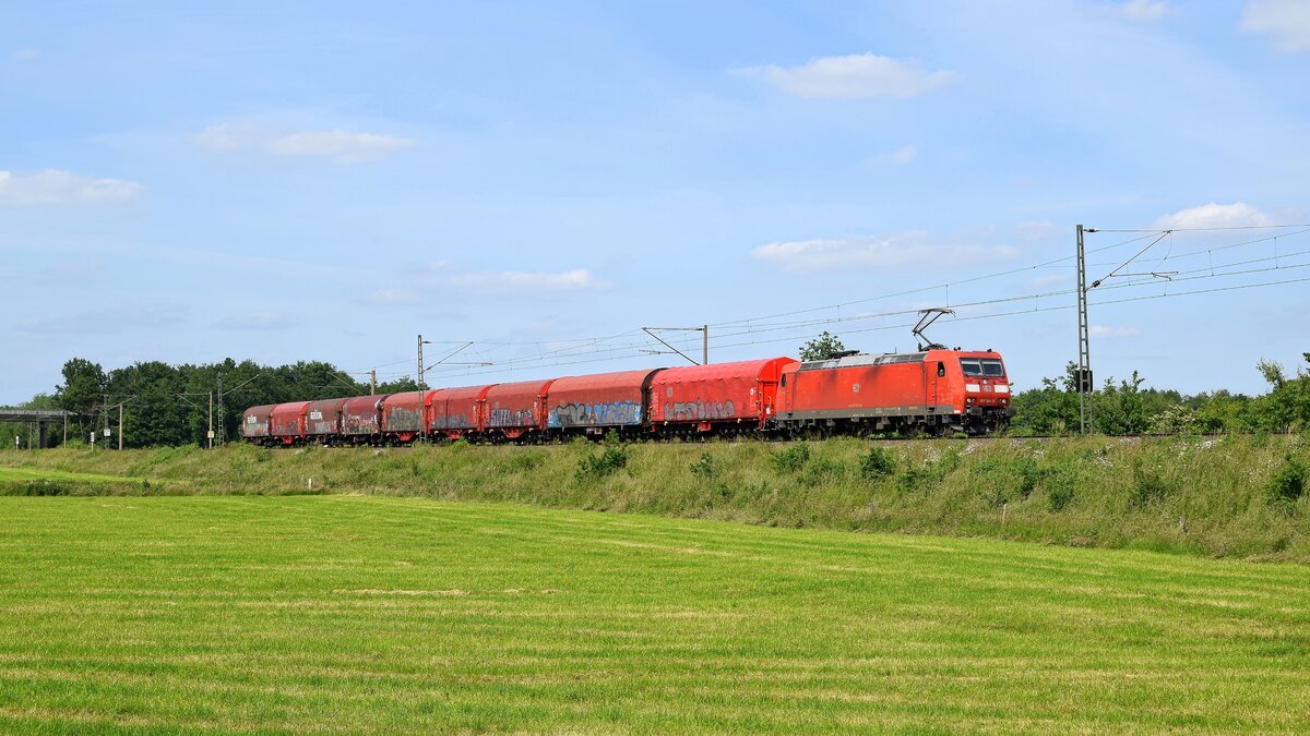 DB Cargo 185 184 mit Schiebeplanwagenzug in Richtung Osnabrück (Hüde, 15.06.2021).