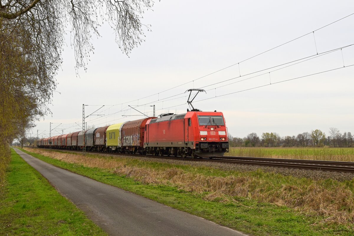 DB Cargo 185 271-4 mit Schiebeplanenwagenzug in Richtung Osnabrück (bei Lembruch, 27.03.2024).