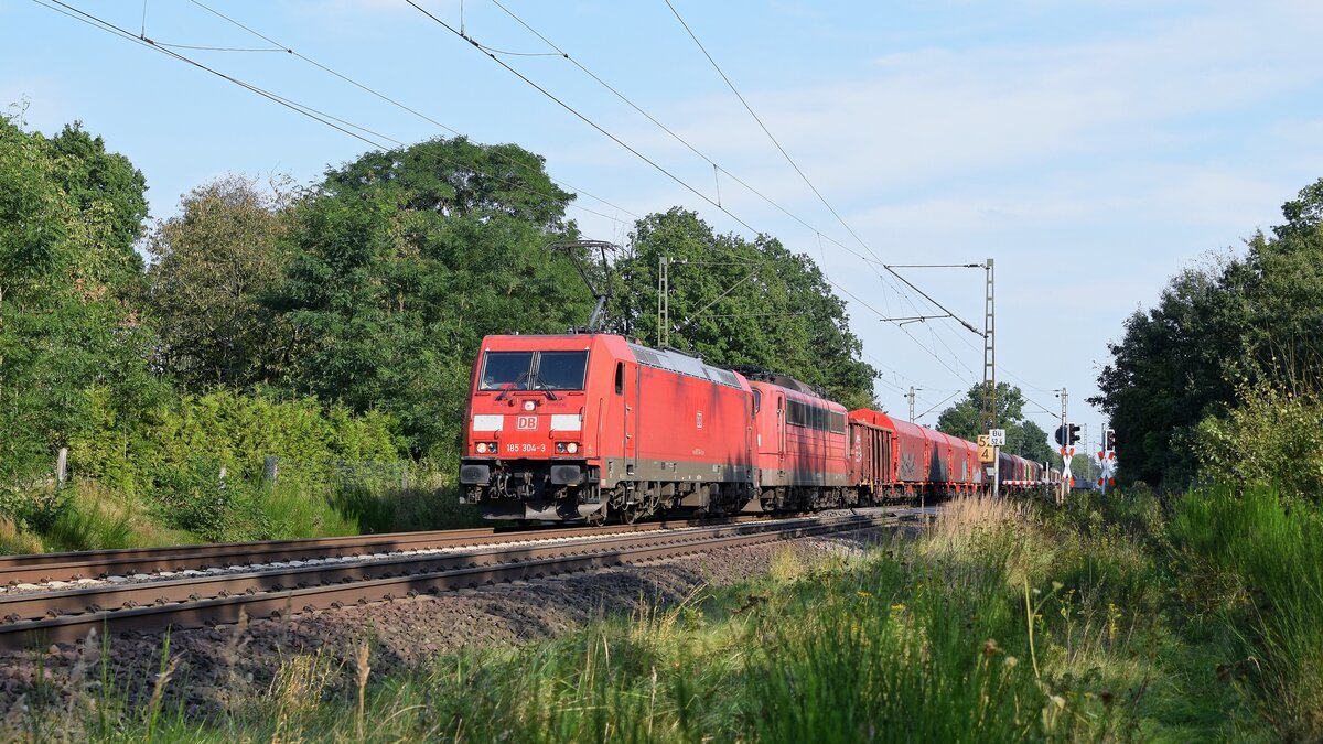 DB Cargo 185 304 mit Wagenlok Railpool 151 032, vermietet an DB Cargo, und gemischtem Güterzug in Richtung Bremen (Nienburg, 14.09.2021).