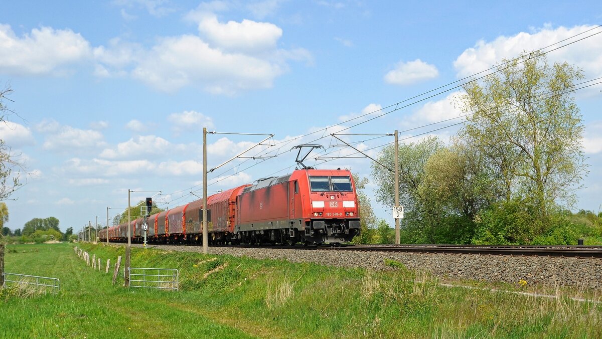 DB Cargo 185 348 mit Schiebeplanenwagenzug in Richtung Osnabrück (Hüde, 06.05.2022).