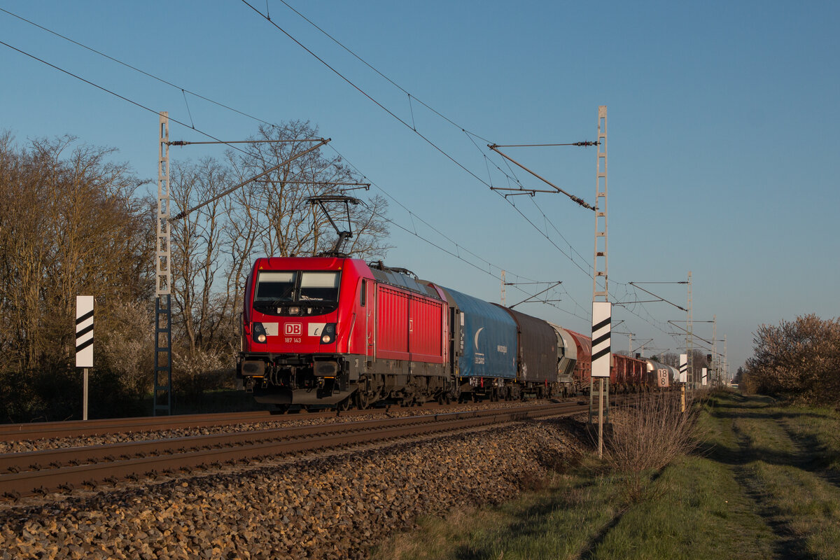 DB Cargo 187 143-3 mit einem gemischten Güterzug in Richtung Halle. Fotografiert am 05.04.2023 in Schönebeck-Felgeleben. 