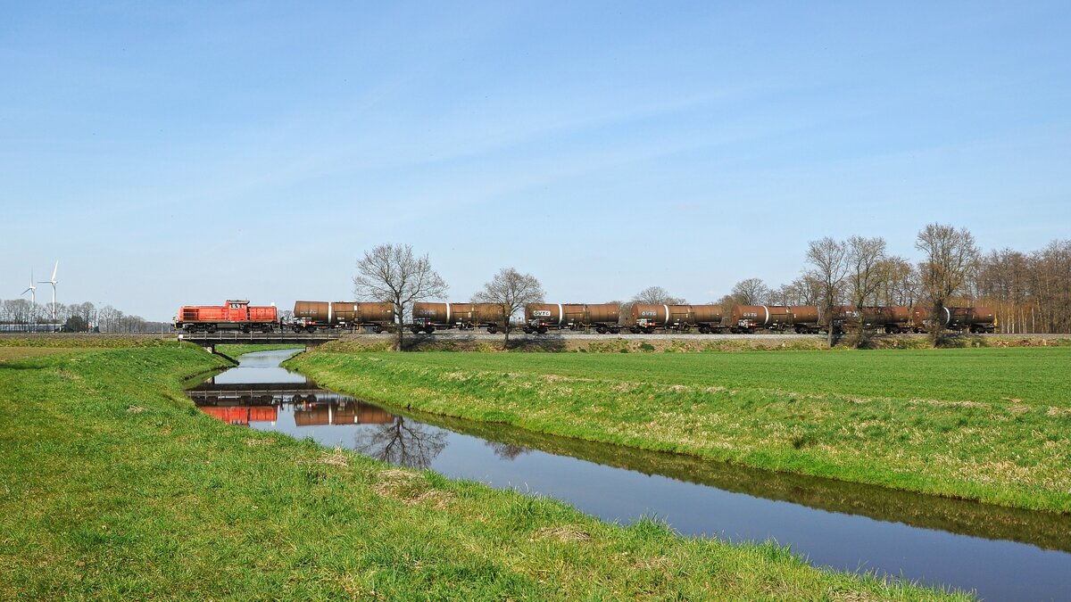 DB Cargo 294 955 (ex 290 111, 294 905) mit dem montags (werktags) verkehrenden Erdölzug EZ 50760 Barenburg - Lingen-Holthausen überquert die Wagenfelder Aue (Barver, 11.04.2022). - Die Erdölzüge von Barenburg nach Lingen - Holthausen werden von Barenburg bis Diepholz mit Dieselloks der Baureihe 294 befördert. Ab Diepholz übernehmen Elektroloks die Traktion. In diesem Fall war es DB Cargo 185 353.