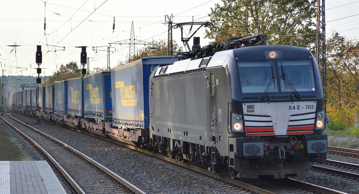 DB Cargo AG [D] mit der MRCE Vectron  X4 E - 703  [NVR-Nummer: 91 80 6193 703-6 D-DISPO] und Taschenwagenzug (LKW Walter Trailer) am 22.10.19 Durchfahrt Bf. Saarmund.