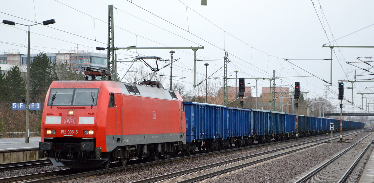 DB Cargo AG [D] mit  152 005-5  [NVR-Nummer: 91 80 6152 005-5 D-DB] und einem Ganzzug polnischer offener Drehgestell-Güterwagen am 08.02.22 Durchfahrt Bf. Flughafen BER - Terminal 5.