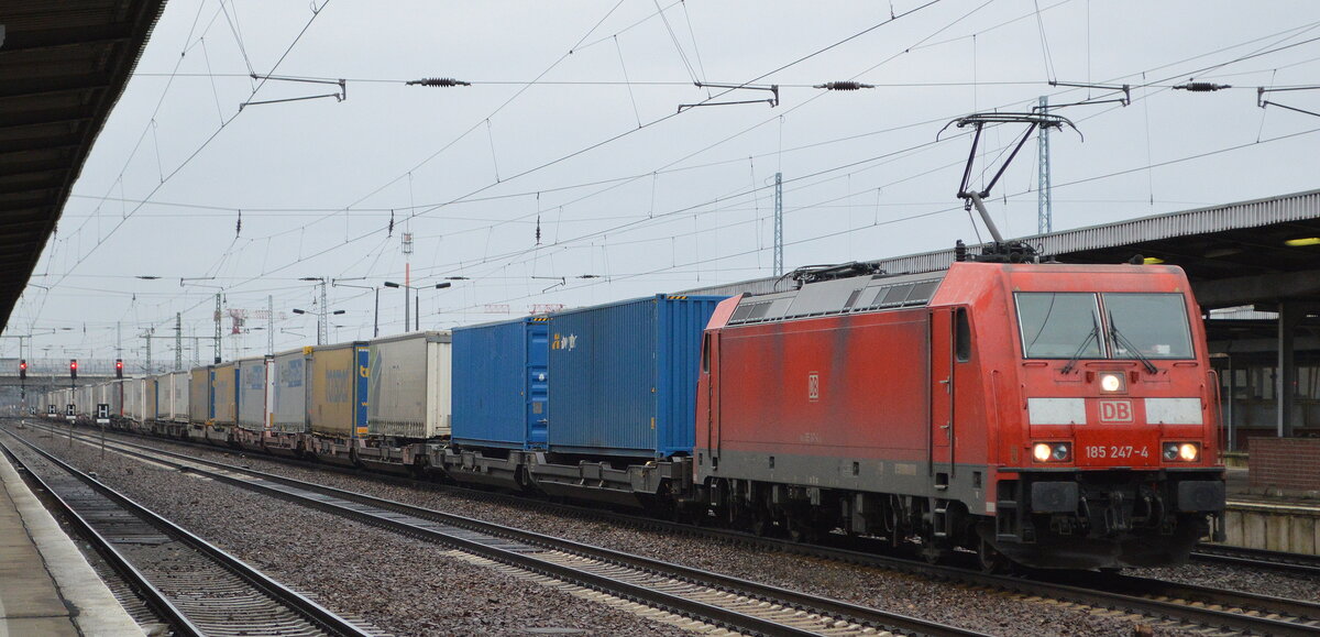 DB Cargo AG [D] mit  185 247-4  [NVR-Nummer: 91 80 6185 247-4 D-DB] und KLV-Zug aus Rostock-Seehafen am 08.02.22 Durchfahrt Bf. Flughafen BER - Terminal 5.
