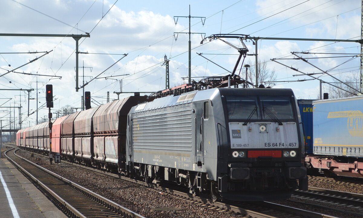 DB Cargo AG [D] mit der polnischen MRCE Dispo  ES 64 F4-457  [NVR-Nummer: 91 51 5170 031-6 PL-DISPO] und einem kurzem Schüttgutwagenzug (Erz?) am 23.02.22 Durchfahrt Bf. Flughafen BER - Terminal 5.