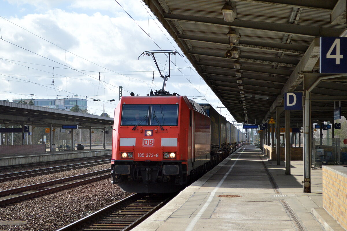 DB Cargo AG [D] mit  185 373-8  [NVR-Nummer: 91 80 6185 373-8 D-DB] fährt mit KLV-Zug Richtung Rostock-Seehafen zum Fahrerwechsel im Bf. Flughafen BER - Terminal 5.ein, 24.02.22