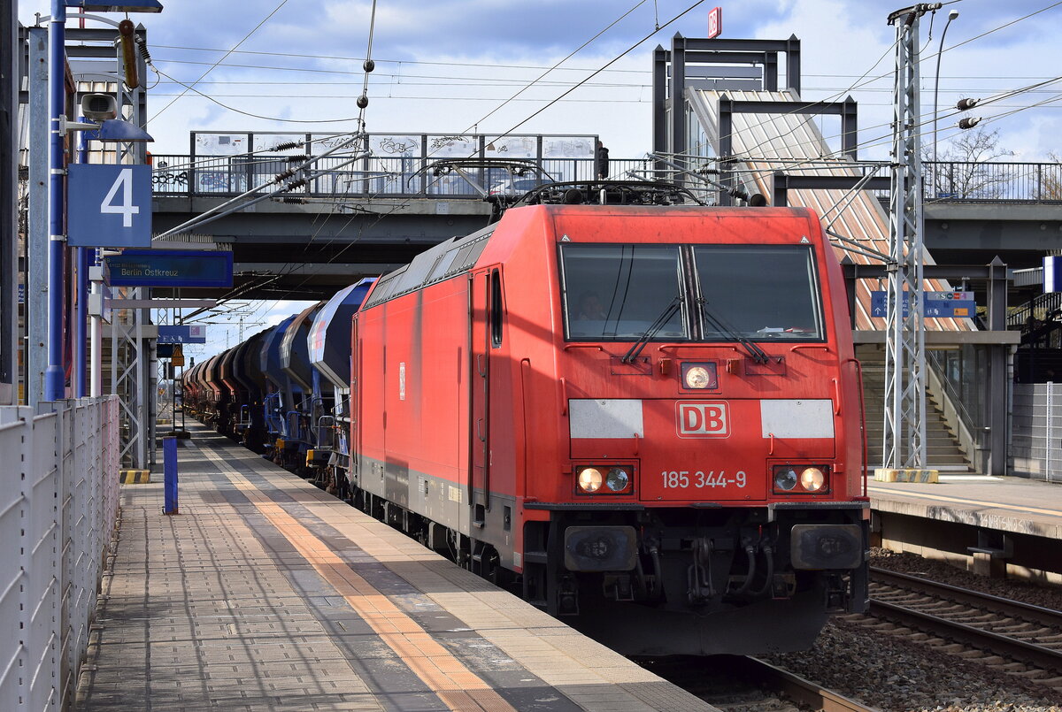 DB Cargo AG [D] mit ihrer  185 344-9  [NVR-Nummer: 91 80 6185 344-9 D-DB] und einem Schotterzug am 04.04.23 Durchfahrt Bahnhof Berlin Hohenschönhausen.
