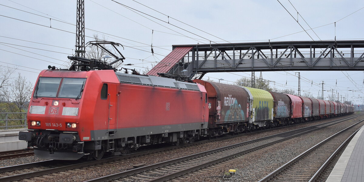 DB Cargo AG [D] mit ihrer  185 143-5  [NVR-Nummer: 91 80 6185 143-5 D-DB] und einem Coilzug Richtung Rbf. Seddin am 18.04.23 Durchfahrt Bahnhof Saarmund.