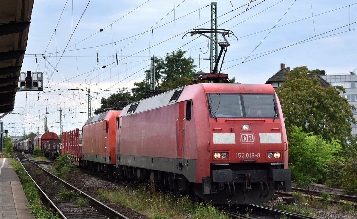 DB Cargo AG [D] mit ihrer  152 018-8  [NVR-Nummer: 91 80 6152 018-8 D-DB] mit  145 039-4  [NVR-Nummer: 91 80 6145 039-4 D-DB] + gemischtem Güterzug am Haken am 30.08.23 Vorbeifahrt Bahnhof Magdeburg-Neustadt. 