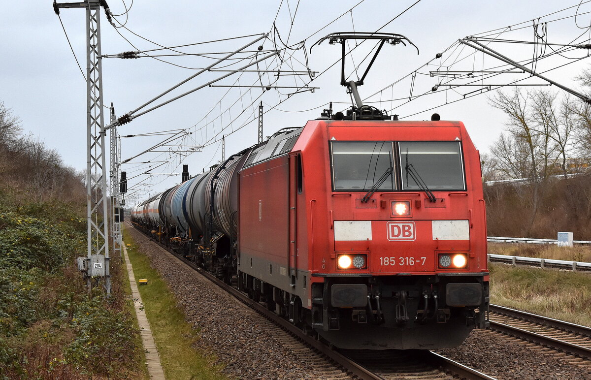 DB Cargo AG, Mainz mit ihrer  185 316-7  (NVR:  91 80 6185 316-7 D-DB ) und einem gemischten Kesselwagenzug am 03.01.24 Durchfahrt Bahnhof Berlin-Hohenschönhausen.