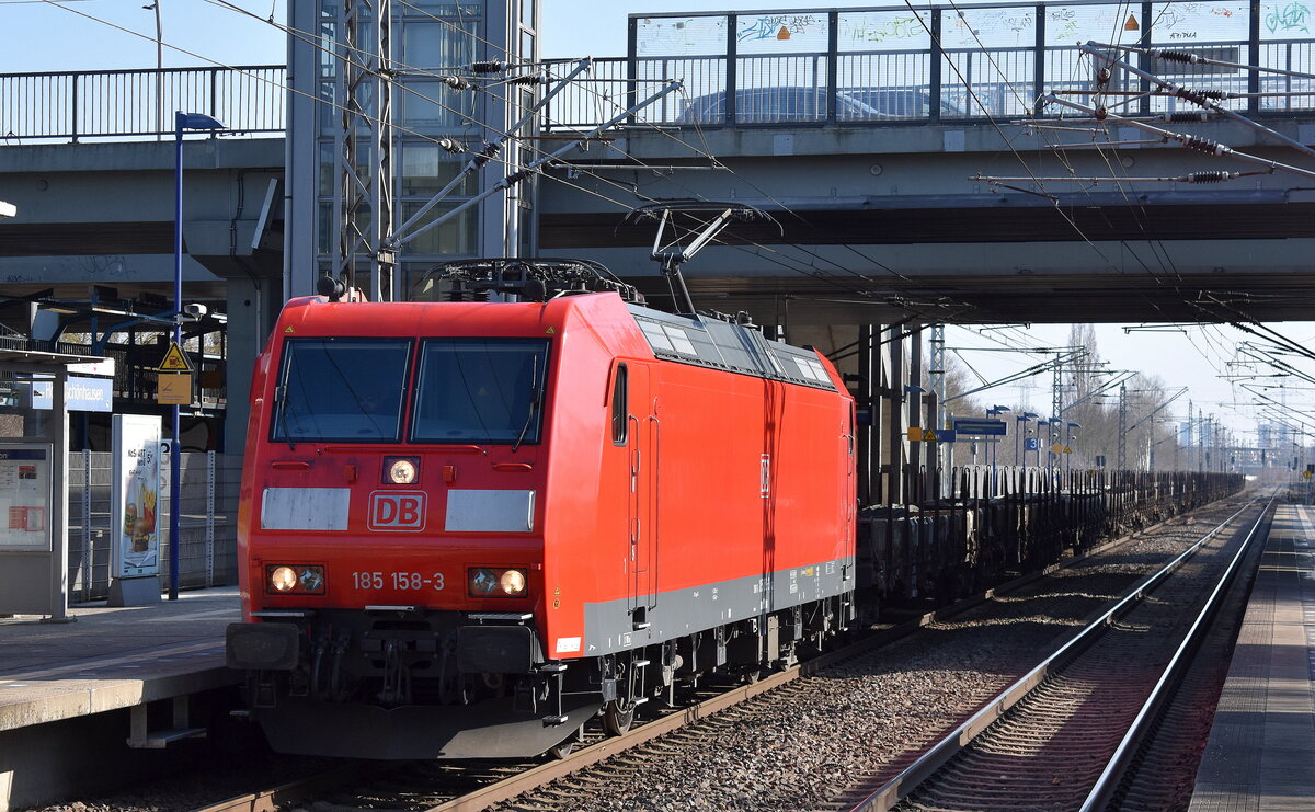 DB Cargo AG, Mainz mit ihrer  185 158-3  (NVR:  91 80 6185 158-3 D-DB ) und einem Ganzzug Drehgestell-Flachwagen mit Bewehrungsstahl beladen am 08.03.24 Durchfahrt Bahnhof Berlin-Hohenschönhausen.