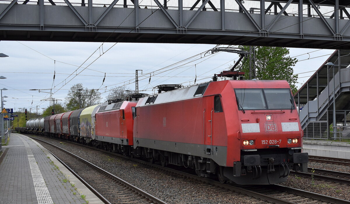 DB Cargo AG, Mainz mit ihrer  152 028-7  (NVR:  91 80 6152 028-7 D-DB ) mit  145 016-2  [NVR-Nummer: 91 80 6145 016-2 D-DB] und gemischtem Güterzug am Haken am 11.04.24 Höhe Bahnhof Saarmund.