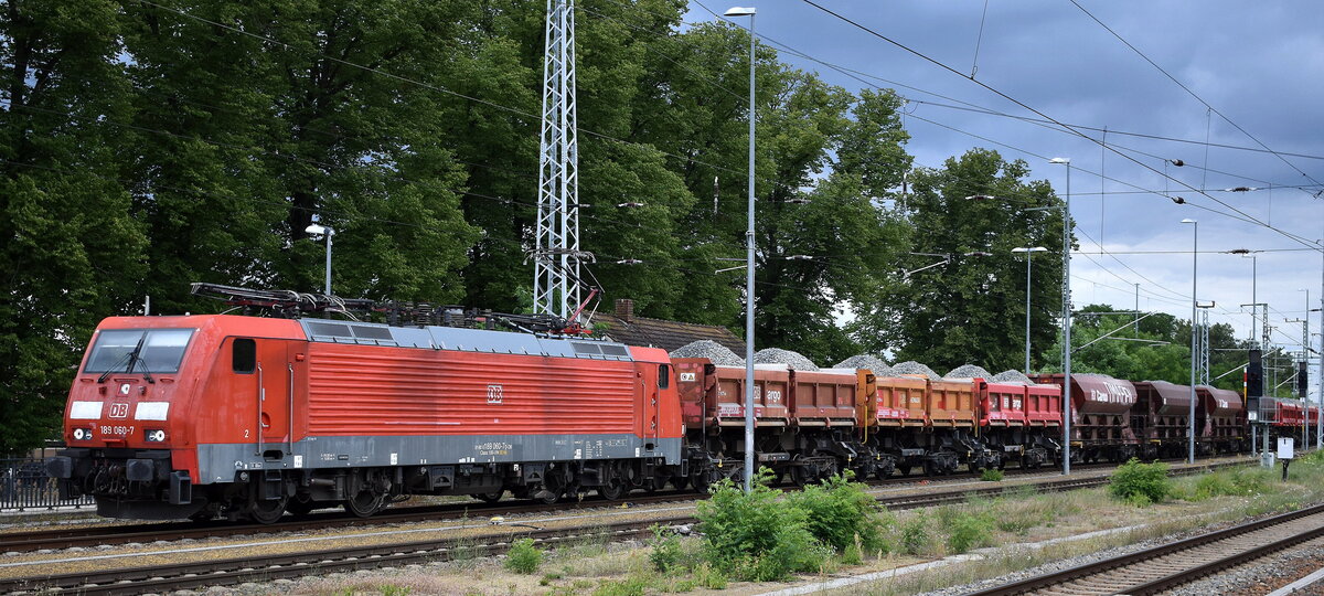 DB Cargo AG, Mainz mit ihrer   189 060-7  [NVR-Nummer: 91 80 6189 060-7 D-DB] und einem Schotterzug am 03.07.24 Höhe Bahnhof Ruhland.