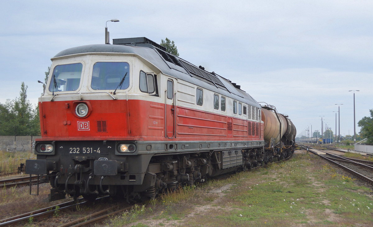 DB Cargo AG mit  232 531-4  (NVR-Nummer  92 80 1232 531-4 D-DB ) verlässt am 30.09.20 den Güterstützpunkt am Bf. Kostrzyn in Polen mit einem Kesselwagenzug für Kreideschlammtransporte (Bild vom Ende des Bahnsteigs über ein Gitter in Brusthöhe).