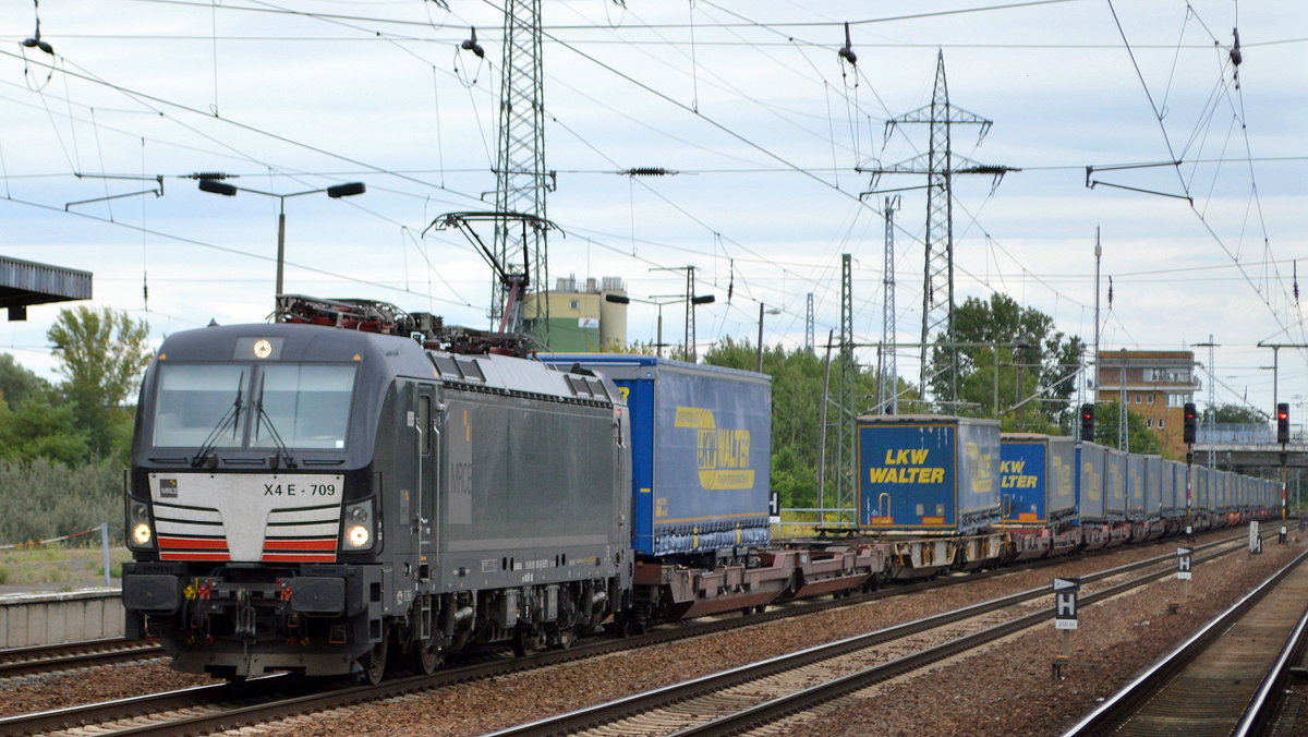 DB Cargo AG mit der MRCE Dispo Vectron   X4 E - 709   [NVR-Nummer: 91 80 6193 709-3 D-DISPO] und KLV ZUg (LKW Walter Trailer) am 15.08.19 Durchfahrt Bahnhof Flughafen Berlin Schönefeld.