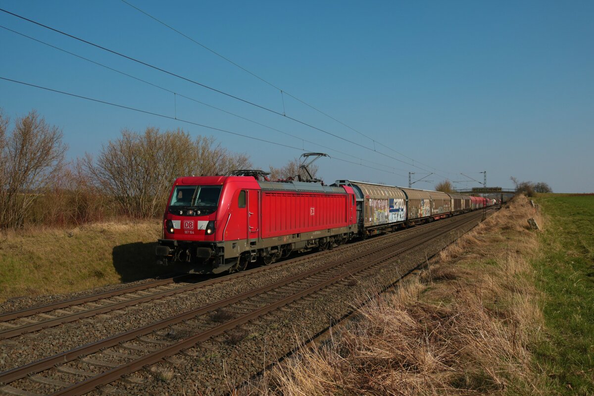 DB Cargo Bombardier Traxx 187 164-9 mit einen Mischer am 24.03.22 in Nieder-Mörlen