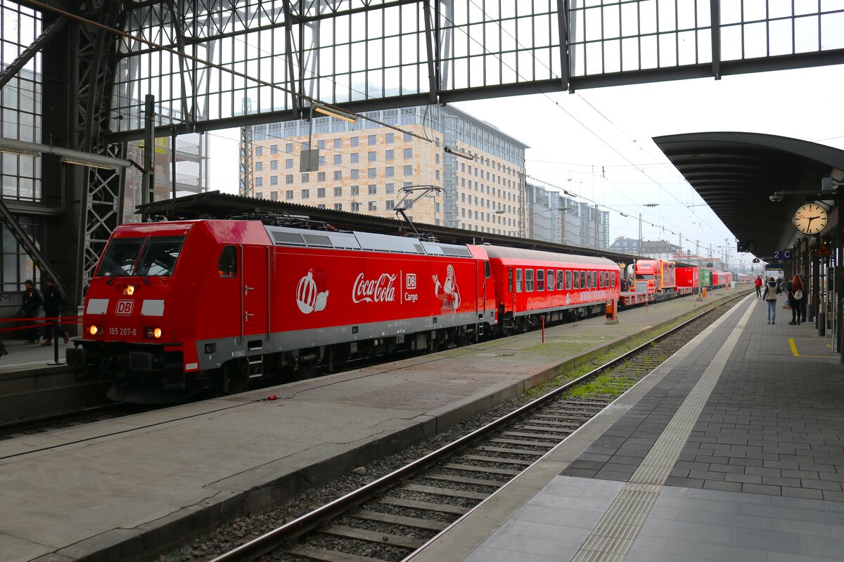 DB Cargo Coca Cola Zug am 17.12.23 in Frankfurt am Main Hbf mit Bombardier Traxx 185 207-8 und dem Coca Cola Truck auf einen Flachwagen
