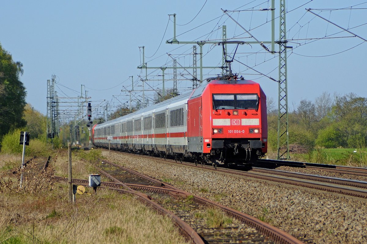 DB Fernverkehr 101 004 und 101 114 (am Schluss) mit IC 2213 Stralsund Hbf - Stuttgart Hbf. Fotografiert auf dem Bahnübergang über das z. Z. nicht mehr benutzte Anschlussgleis zum Fliegerhorst Diepholz (Diepholz, 17.04.2020).