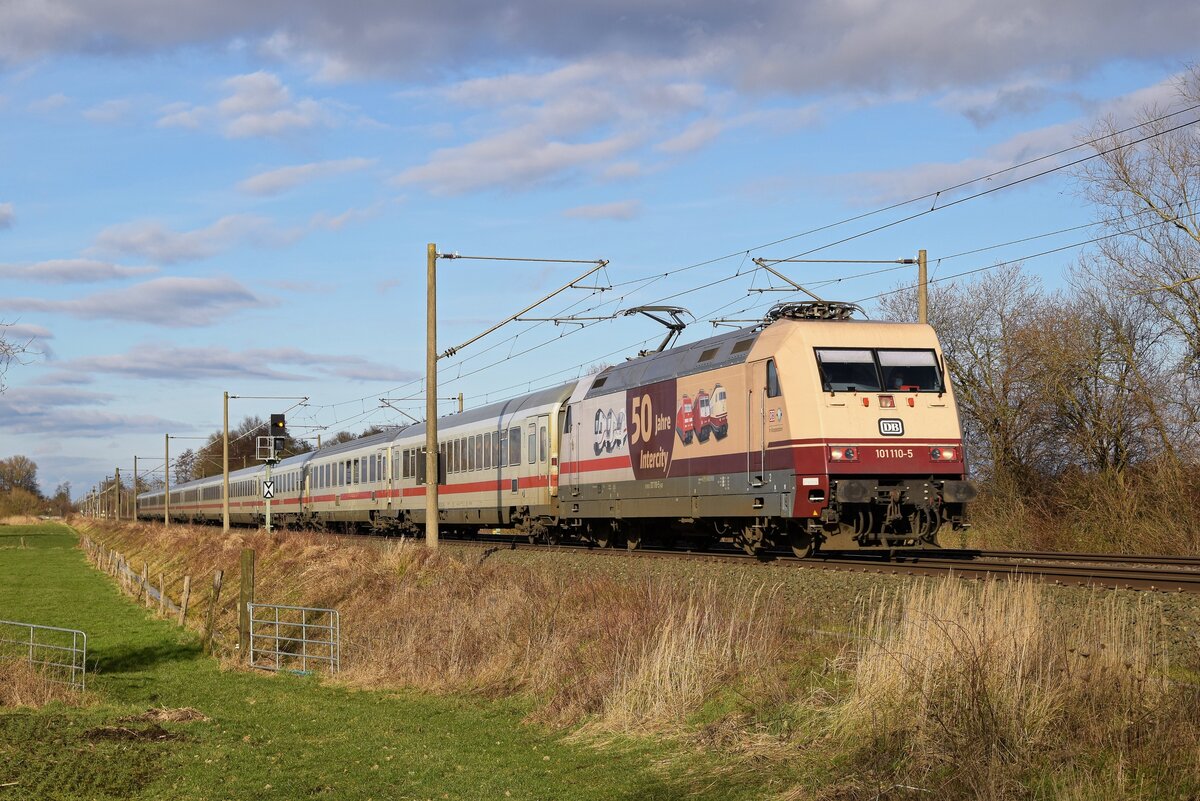 DB Fernverkehr 101 110  50 Jahre Intercity  mit IC 2311 Westerland (Sylt) - Stuttgart Hbf. Am Zugschluss befindet ein Steuerwagen ebefalls mit  50 Jahre Intercity -Folierung (Hüde, 14.02.2022).