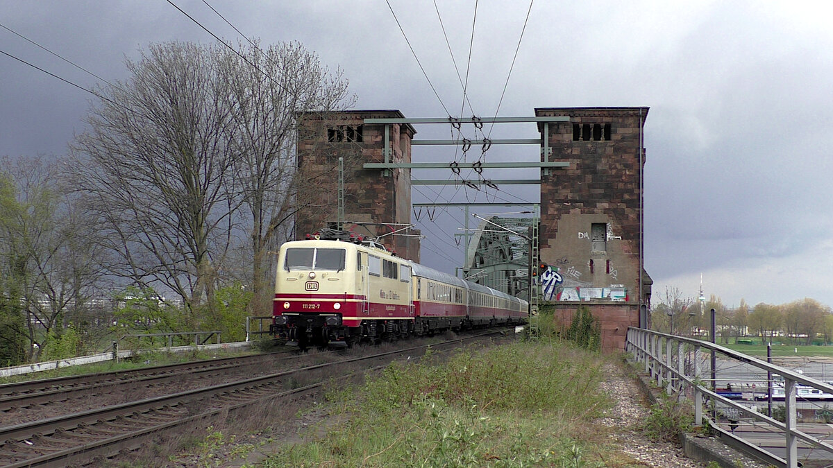 DB Gebrauchtzug 111 212-7 zieht am 09.04.2022 den AKE-Rheingold anlässlich einer Köln-Rundfahrt über die Südbrücke in Richtung Bonntor.