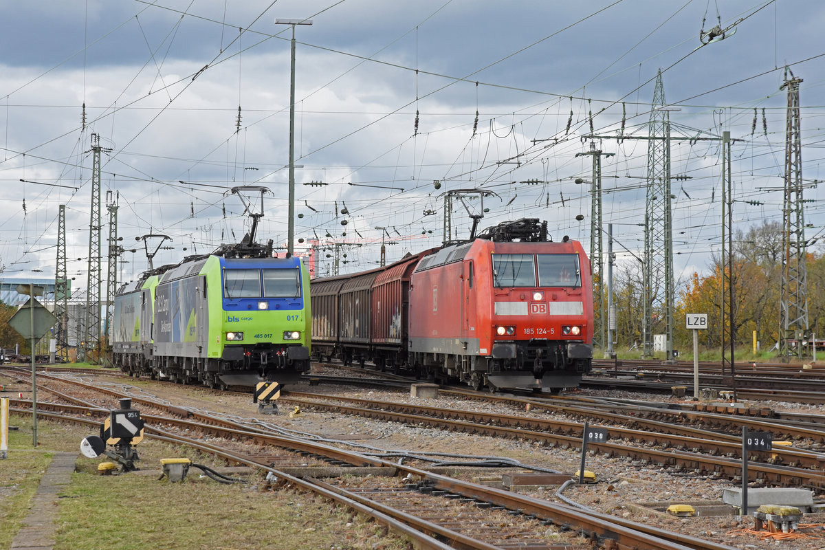 DB Lok 185 124 durchfährt den badischen Bahnhof. Daneben steht die Doppeltraktion, mit den BLS Loks 485 017-8 und 475 409-9. Die Aufnahme stammt vom 06.11.2019.