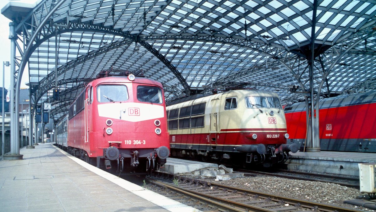 DB Regio 110 304 mit Regionalzug, danenben DB Fernverkehr 103 226 mit IC (Köln Hbf, 01.06.1999); digitalisiertes Dia.