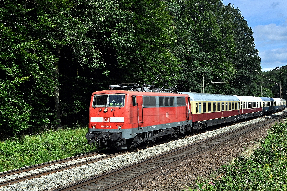 DB Regio 111 048, im Einsatz für DB Fernverkehr, befindet sich am 22.07.12 im Wiehengebirge zwischen Ostercappeln und Vehrte mit dem sonntäglichen IC 2417 auf der Fahrt von Flensburg nach Köln Hbf. Der Zugzielanzeiger im Lokfenster deutet darauf hin, dass das eigentliche Einsatzgebiet der Lok einige hundert Kilometer weiter südlich liegt.