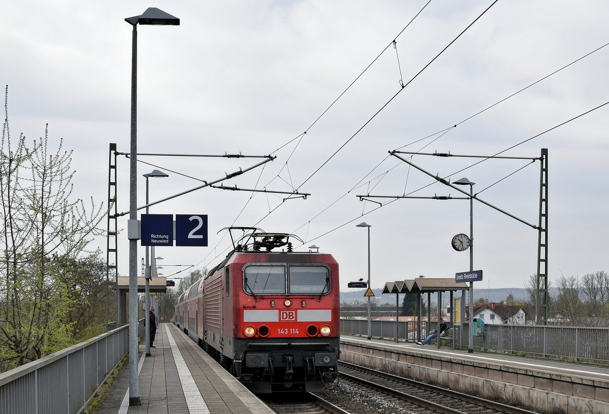 DB Regio 143 114 mit RB 12512 Koblenz Hbf - Rommerskirchen macht am 09.04.18 Station am Haltepunkt Urmitz Rheinbrcke kurz vor der berquerung des Rheins.