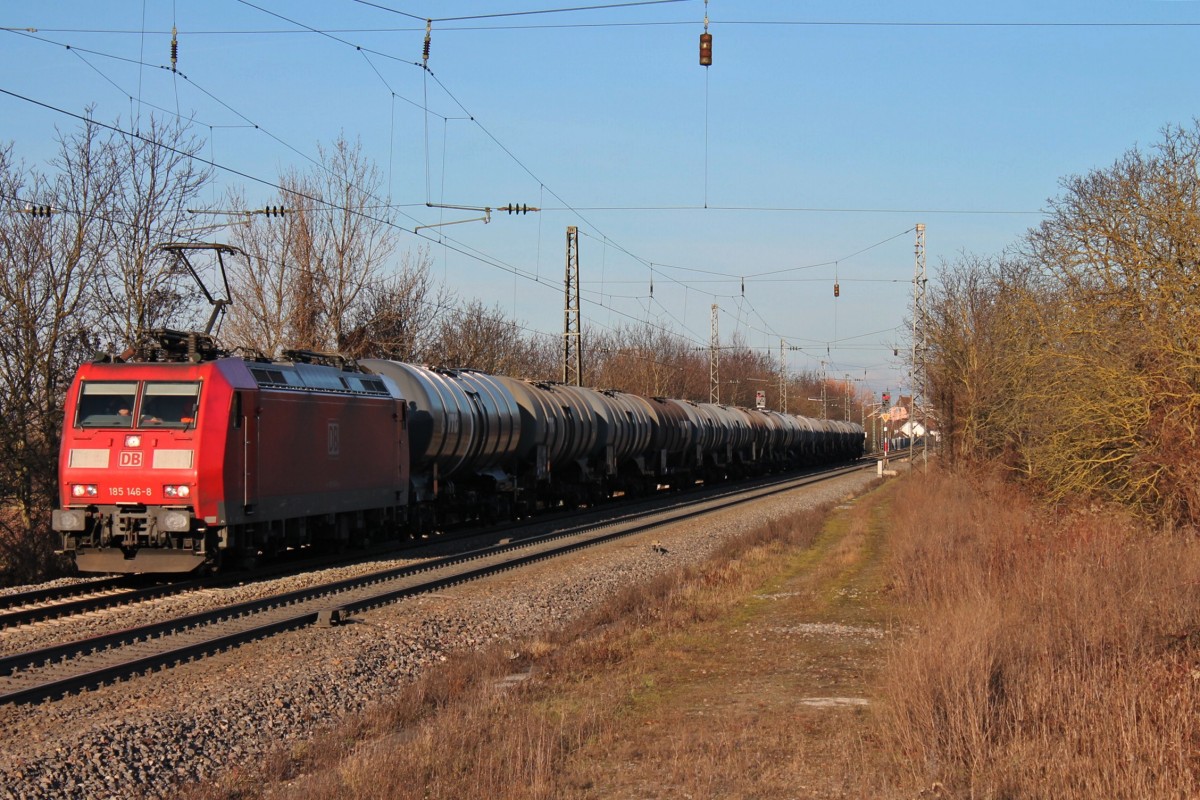 DB Schenker 185 146-8 am 23.12.2013 mit einem Kesselwagenganzzug und mit der Abendsonne bei der Durchfahrt in Heiterheim gen Süden.