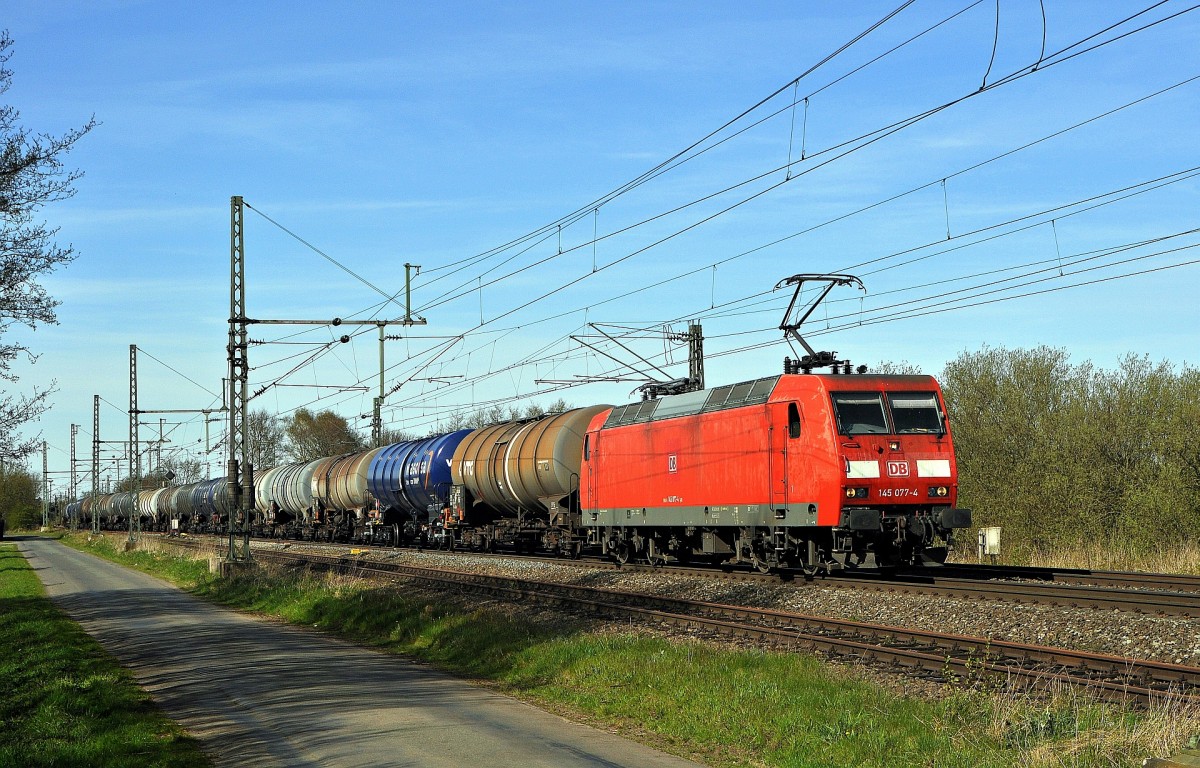 DB Schenker Rail 145 077 setzt am 20.04.15 in Diepholz seine Fahrt mit einem Kesselwagenzug in Richtung Osnabrück nach Überholung durch einen IC fort. 