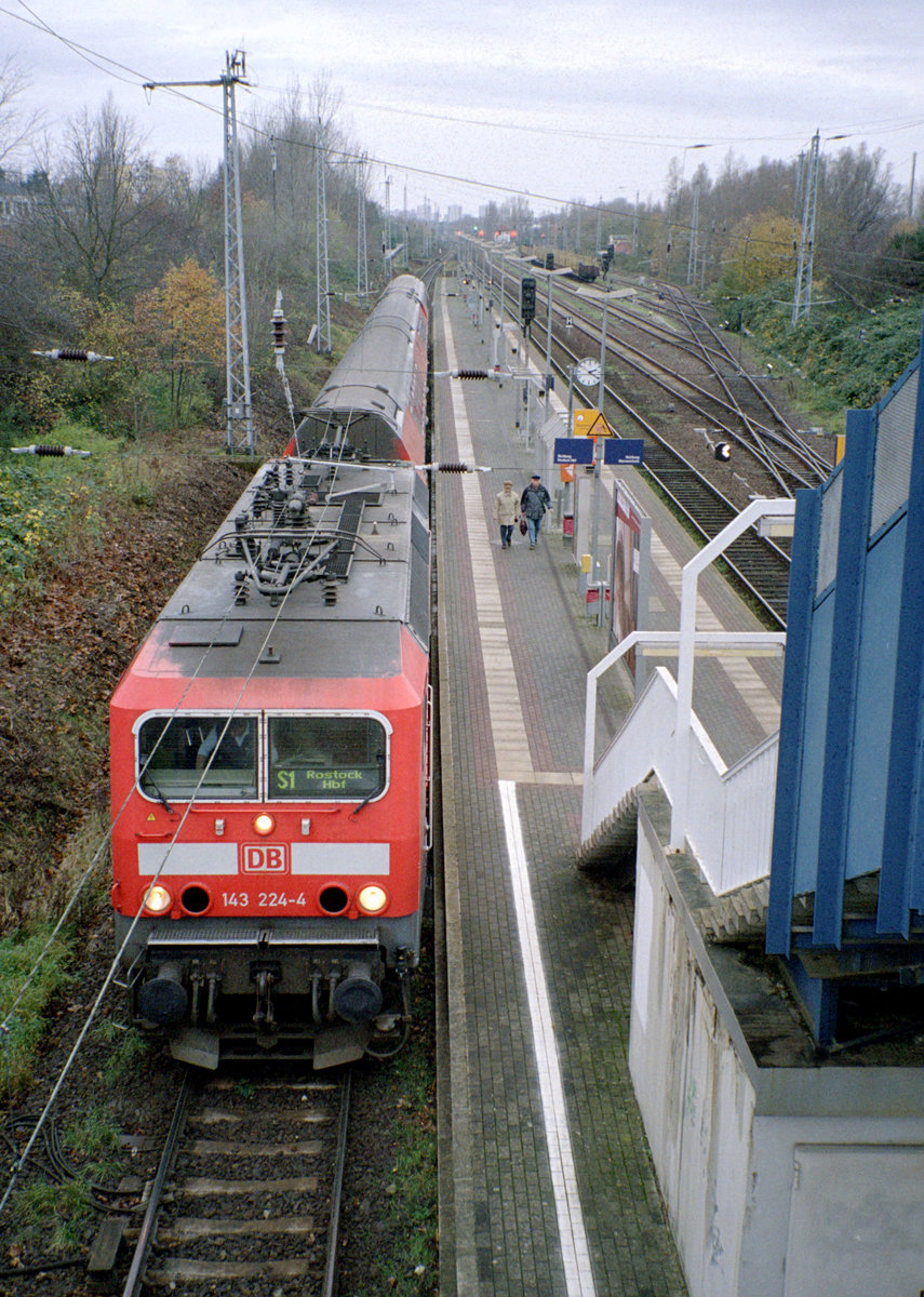 DBAG S-Bahn Rostock: Im S-Bahnhaltepunkt Rostock-Bramow hält am 25. November 2006 die 143 224-4 mit Doppelstockwagen als S1. Der Zug fährt in Richtung Rostock Hbf. - Scan eines Farbnegativs. Film: Kodak FB 200-6. Kamera: Leica C2.