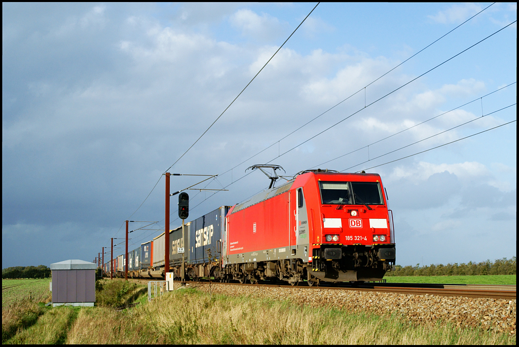 DBSRS 185 321-4 ist am 13.09.2011 mit einem KLV-Zug in Richtung Deutschland in der Nähe von Lovtrup Vestermark unterwegs und erwischt vor der nächsten aus Nordwesten aufziehenden Regenfront gerade noch ein Wolkenloch.
