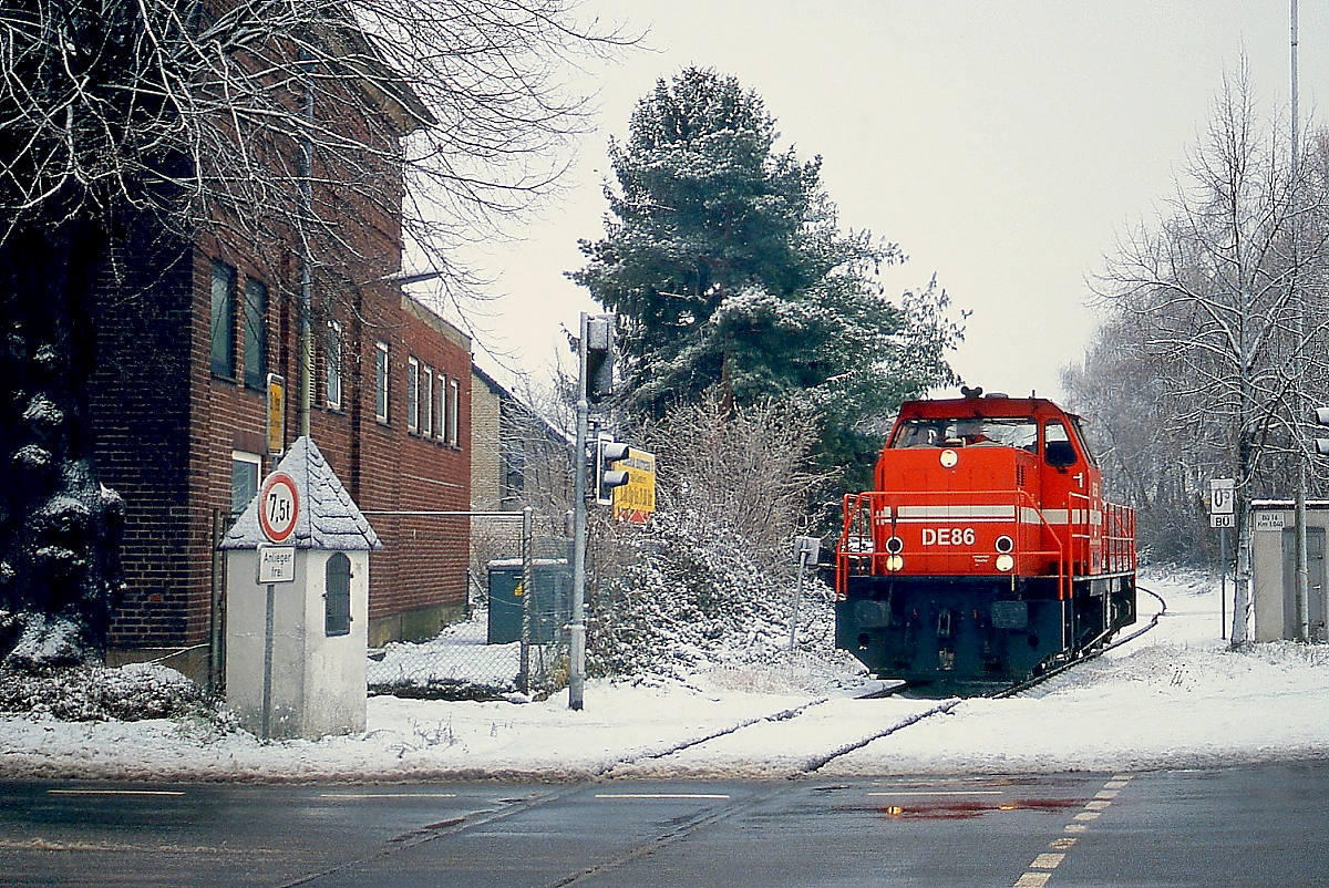 DE 86 der HGK Köln überquert am 17.12.2010 den Bahnübergang Bahnstraße in Dormagen-St. Peter, um Güterwagen aus dem Hafen Stürzelberg abzuholen