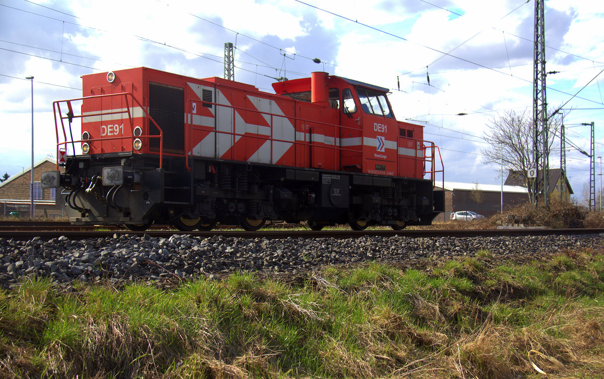 DE91 von Rheincargo steht mit Licht an im Güterbahnhof von Nievenheim. Aufgenommen vom einem Weg am Kirschfeld in Nievenheim. 
Bei Sonnenschein und Regenwolken am Nachmittag vom 31.3.2018.