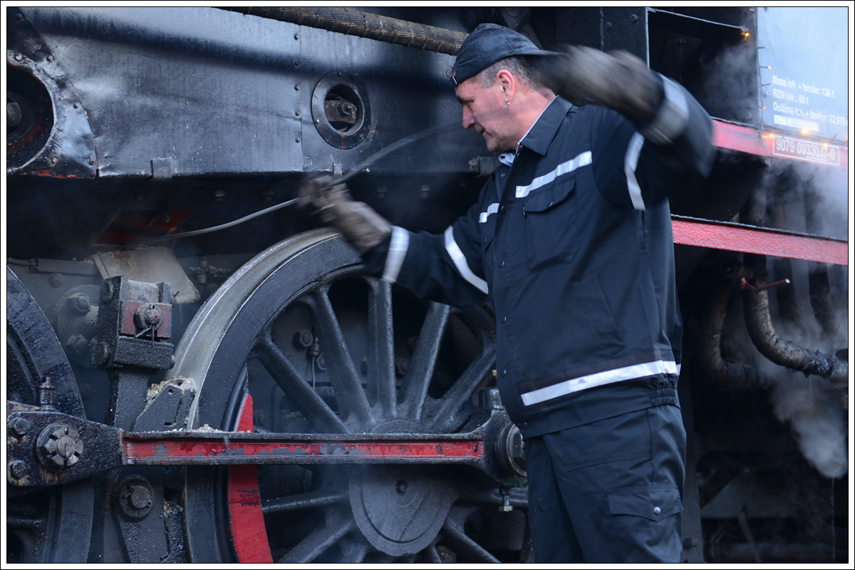 Dejan beim Reinigen des Aschenkasten der 33-037 am 17.12.2016 in Novo Mesto.