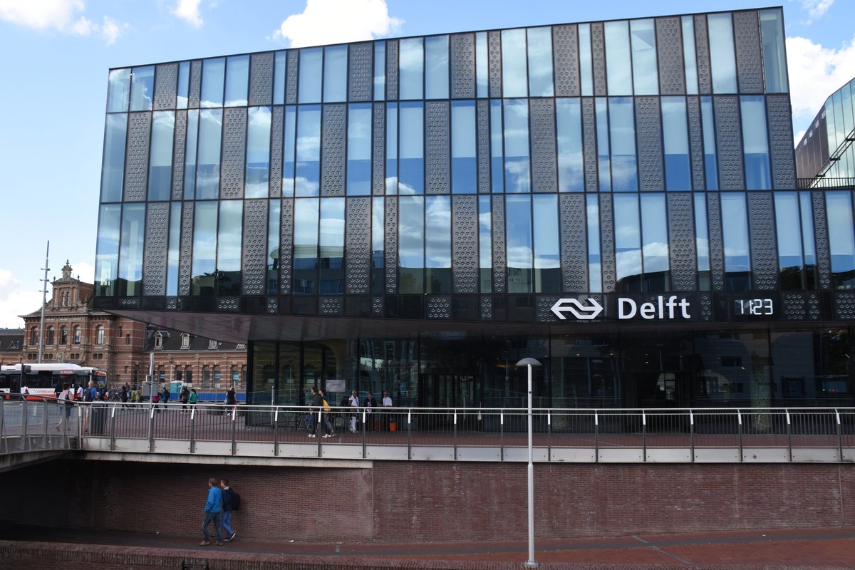 DELFT (Provinz Zuid-Holland), 06.08.2017, Delft Station, ein nagelneuer, moderner Bahnhof mit im Tunnel (erbaut zwischen 2009 und 2015) befindlichen Gleisen; links ist das alte Bahnhofsgebäude erkennbar